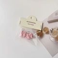 Detailed view of pink bow hair clips with camellia accents in summer lifestyle setting - Bow Claw Clip