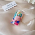 Detailed macro view of colorful elastic hair ties in a clear bottle on champagne satin - Jar Multicolor