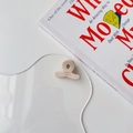 Detail of a beige handmade acetate mini hair claw clip resting on an acrylic board - Milk White