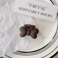 Close-up of matte dark brown butterfly hair claw clip on elegant white ceramic plate - Bowknot Style / Matte Brown Butterfly