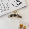 Détail d'une pince à cheveux ambrée avec perles marbrées sur un fond de style de vie - Gris