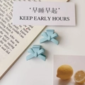 Detail shot of light blue matte bow hair clips on a minimalist lifestyle background - Matte Blue (Plastic)