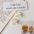 Close-up of cream white matte bow hair clips on a decorative lifestyle background - Matte White (Plastic)