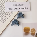 Detailed view of matte blue and dark grey mini bow claw clips for side hair styling - Matte Haze Blue (Plastic)