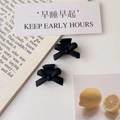 Close-up of dual matte black bow hair clips on a minimalist French lifestyle background - Matte Black (Plastic)