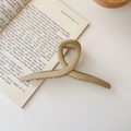 Matte beige oversized hair claw clip resting on a book for casual styling - Matte Cross Style / Extra Large / Matte Khaki