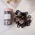 Close-up of high elasticity hair ties in earth tones stored in a clear jar with a pink lid - Coffee Colors Ice Cream Cup