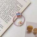 Elastico per capelli rosa con ciondolo cupcake 3D ed etichetta floreale su libro - Elastico Cupcake