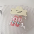 Dettaglio di due fermagli per capelli floreali in confezione su vassoio di vetro - Stile Doppio / Rosa chiaro