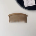 Gros plan sur le peigne à cheveux marron mat avec sa structure courbée multi-dents - Khaki