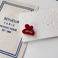 Detail of red French barrette with Barrette la France text on textured stone - Burgundy
