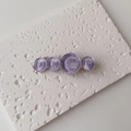 Detailed macro view of purple resin hair clip with wavy circular motifs and golden metal base - Single Piece / Large / Purple