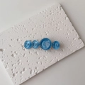 Detailed close-up of blue resin ocean-wave circles on a gold hair clip with pearly texture - Single Piece / Large / Blue