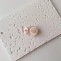 Macro detail of pink pearlescent wave circle hair clips with glitter finish on white stone - Single Piece / Small / Light Pink