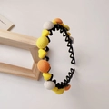 Dettaglio del cerchietto ondulato con ciondoli a cuore e palline di maglia colorate - Arancione Cerchietto Tondo