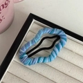 Macro shot of blue gradient yarn-wrapped BB hair clip on a beige velvet jewelry tray - Blue