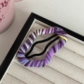Close-up of colorful hand-knitted purple yarn wrapped around a metal BB hair clip - Purple