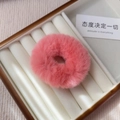 Close-up of a fluffy pink plush scrunchie displayed on a white velvet jewelry box base - Watermelon Pink