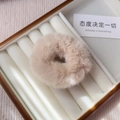 Close-up of soft beige fluffy plush scrunchie displayed in a white jewelry box - Beige