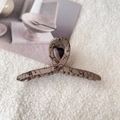 Detailed view of beige shark hair clip with black abstract lines on soft textured fabric - Medium-Coffee