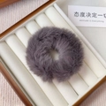 Detail of high-quality fluffy grey plush scrunchie displayed in a wooden jewelry box - Gray