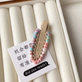 Detail of hand-woven colorful wool yarn on a matte khaki alloy duckbill hair clip - Khaki