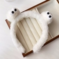 Primo piano del cerchietto in peluche bianco con grandi occhi in scatola di legno - Fascia Stile Mostro Bianco