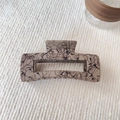 Dettaglio macro di un fermaglio per capelli rettangolare beige da 12,5cm con macchie nere - Pinza Quadrata Piccola - Caffè