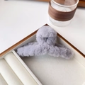 Close-up of a large grey plush faux fur hair claw clip on a white velvet display tray - Small 12cm / Haze Blue