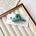 Detalle de una pinza para el pelo de punto verde con motas de colores en una caja blanca - Pinza Pequeña para el Cabello / Verde
