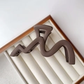 Detail view of the large dark brown wavy hair claw clip with matte finish and metal spring - Frosted / Matte Coffee