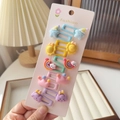 Détail de cinq paires de barrettes enfant en résine colorée sur support cartonné blanc - Petit Style de Soleil