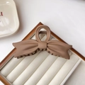 Detailed view of a matte brown oversized bow hair claw clip with a secure grip teeth - Light Coffee