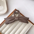 Detail of matte dark brown bow claw clip with non-slip teeth on a velvet display - Dark Coffee