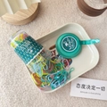Macro shot of 130pcs candy color elastic hair bands spilling from a clear jar on a tray - Lake Green