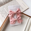 Detail of two pink ribbon bow hair clips on a Fashion Jewelry card with vintage book - Pink