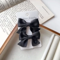 Pair of elegant black satin bow hair clips displayed on a card inside a wooden jewelry box - Black