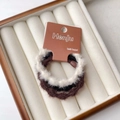 Dettaglio di elastici per capelli in peluche nero, marrone e bianco su cartoncino - Stile Segmentato Bianco e Nero