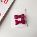 Détail macro de barrettes à nœuds en acétate rouge rubis avec lettrage doré fait main - Fruit du Dragon