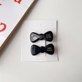 Détail de deux barrettes à nœud noir brillant sur carte avec lettrage doré fait main - Noir