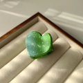 Detail of green heart-shaped hair claw with white polka dots on a velvet tray - Green Gradient