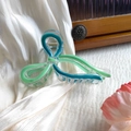 Close-up of translucent mint green butterfly hair claw clip with golden metal spring - Light Green and Blue-Green (Oil Dripping)