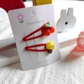 Detailed view of two cute red hair clips with 3D cherry and mushroom on a display card - Red