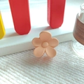 Detailaufnahme der matt hellorangefarbenen Blumen-Haarklammer auf weißem Grund - Milchtee - Matt