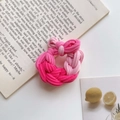 Detailed view of a pink woven hair tie with a bow on top of an open book - Pink Series (Thickened)