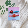 Detail view of handmade acrylic hair clips with berry and orange designs on a card - Waxberry and Orange Duckbill Clip