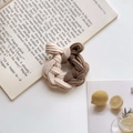 Detail of knitted twist bow hair tie in beige and brown on an aesthetic book background - Milk Coffee Series (Thickened)