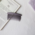 Close-up of a purple matte hair comb clip featuring smooth curved lines and dense teeth - Round Head Afro Comb / Purple