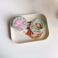 Detail of multi-colored high-elastic hair ties in a branded floral storage box - Spring Color Series
