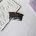 Close-up of a matte dark brown 17-tooth hair side comb for fixing loose hair and bangs - Round Head Afro Comb / Brown